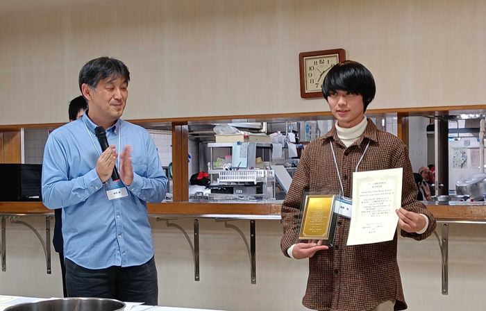 表彰状を持つ眞部さん
